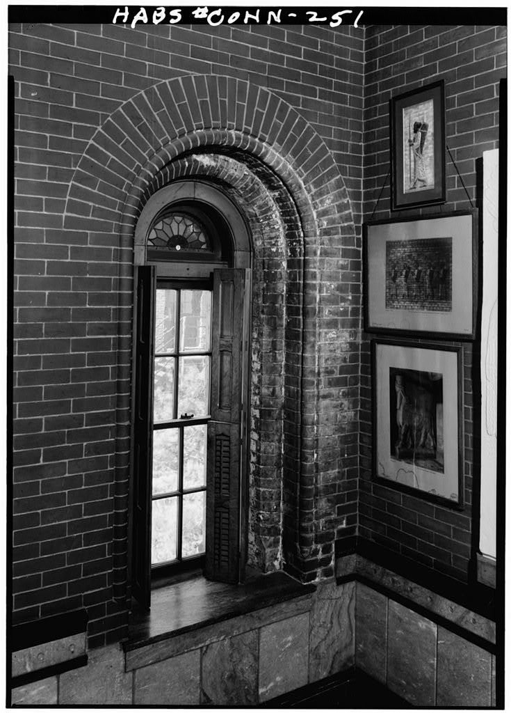 Interior of typical small window with round head and interior shutters